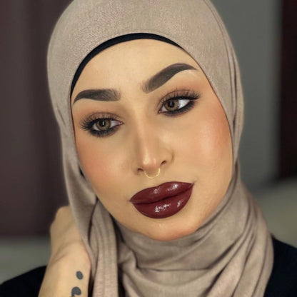 Middle eastern beautiful woman in an hijab wearing bold burgundy lipstick together with hayati lashes model 777 fluffy and lightweight lashes with an invisible band