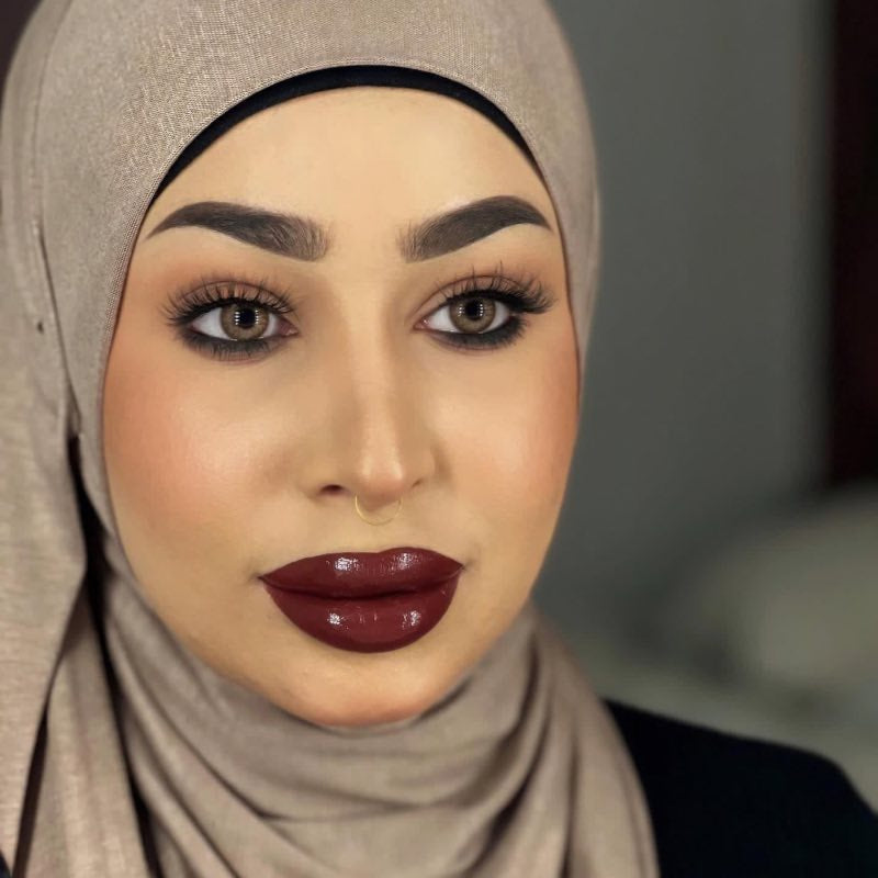 Middle eastern beautiful woman in an hijab wearing bold burgundy lipstick together with hayati lashes model 777 fluffy and lightweight lashes with an invisible band