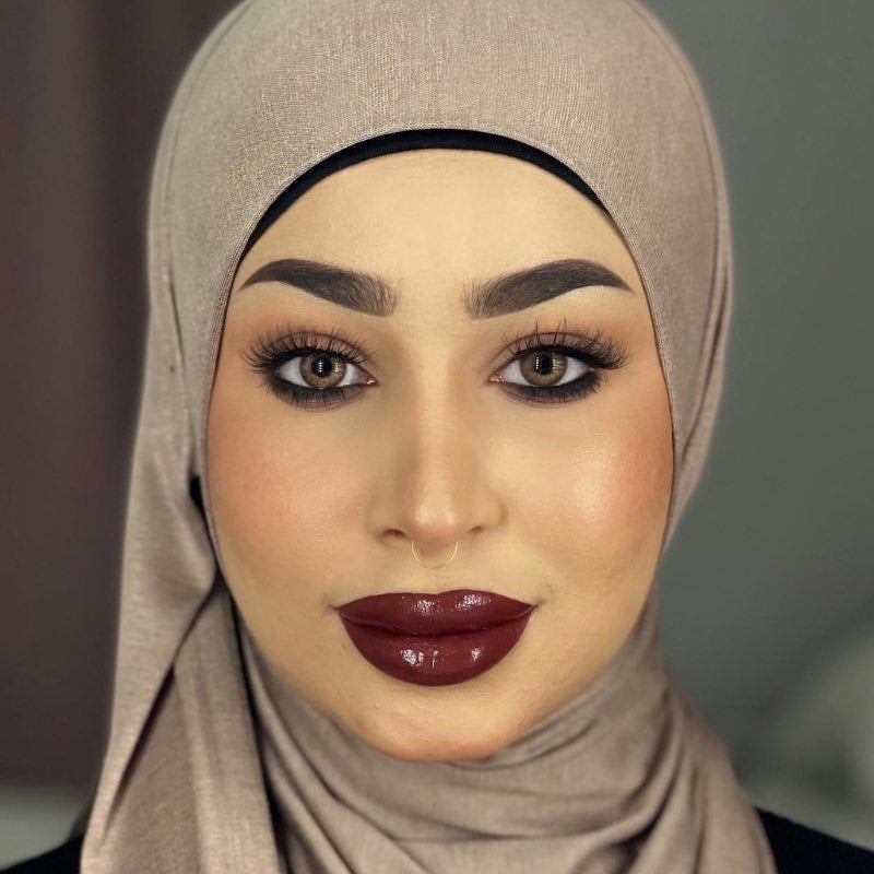 Middle eastern beautiful woman in an hijab wearing bold burgundy lipstick together with hayati lashes model 777 fluffy and lightweight lashes with an invisible band